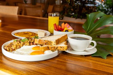 Arepas, kahve, ekmek, yumurta, pirinç ve meyveli Kolombiya kahvaltısı.