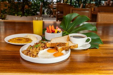 Arepas, kahve, ekmek, yumurta, pirinç ve meyveli Kolombiya kahvaltısı.