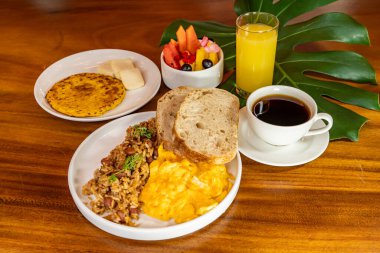 Arepas, kahve, ekmek, yumurta, pirinç ve meyveli Kolombiya kahvaltısı.