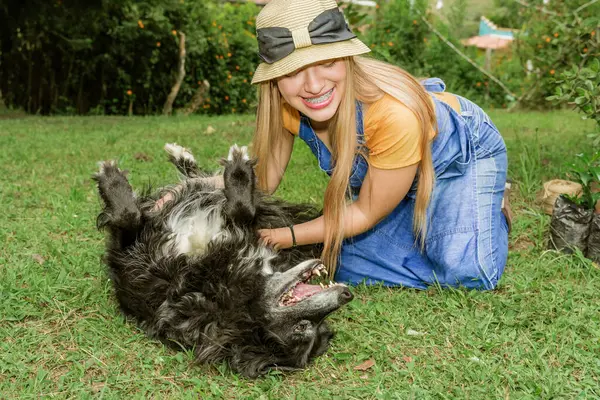 Latin woman playing with old dog