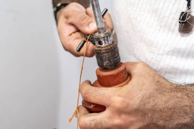 Adam evde matkapla çalışıyor.