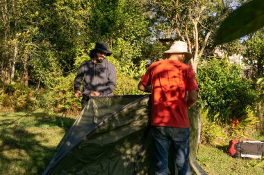 Maceracı adamlar kamp çadırı kuruyor.