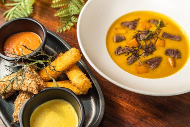 Lezzetli peynir ve sığır filetosu çorbası ile birlikte tavuk parmağı. Restoran yemeği. Başlangıç ve çorba. Otel.