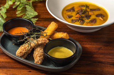 Lezzetli peynir ve sığır filetosu çorbası ile birlikte tavuk parmağı. Restoran yemeği. Başlangıç ve çorba. Otel.