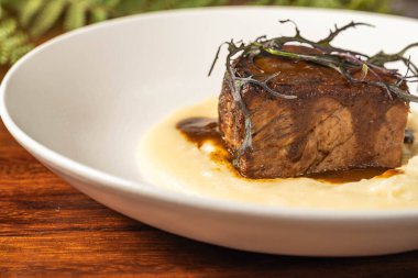 Bir otel restoranında erimiş peynirli nefis biftek. Nefis bir ana yemek..