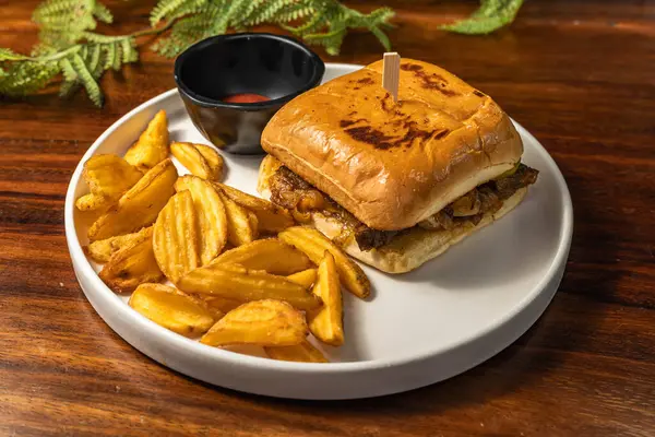 Exquisite sandwich in a hotel restaurant with french fries and red sauce. Tasty fast food.