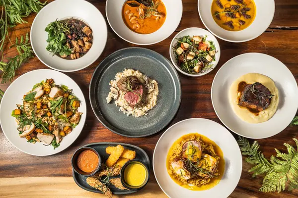 Bir otel restoranında paylaşmak için çeşitli enfes yemekler. Başlangıçlar, salatalar ve ana yemekler. Lezzetli yemekler ve farklı seçenekler..