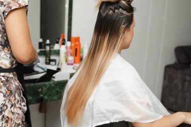 Kuaföründe sarışın müşterisinin saçını kesen stilist. Kadın kuaförü. Saç tıraşı..