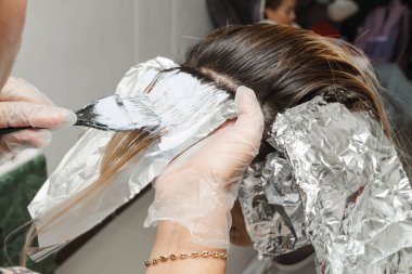 Kuaföründe sarışının saçını beyazlatan stilist. Güzellik salonundaki kadın. Kuaförlük ve kozmetik.