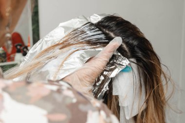 Kuaföründe sarışının saçını beyazlatan stilist. Güzellik salonundaki kadın. Kuaförlük ve kozmetik.