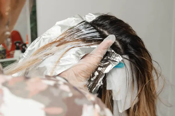 Kuaföründe sarışının saçını beyazlatan stilist. Güzellik salonundaki kadın. Kuaförlük ve kozmetik.