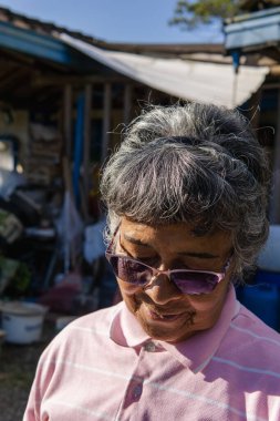 Anneler Günü. Mutlu anne gülümseyerek çiftlikteki gününün tadını çıkarıyor. Gözlüklü yaşlı esmer kadın çok mutlu..