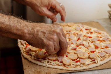 Usta bir adam ailesi için evde pizza yapıyor. Adam yemek yapıyor..