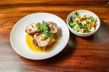 Lezzetli bir sebze salatasıyla birlikte portakal soslu pirinç tabanlı nefis tavuk madalyonları. Otel restoranı.