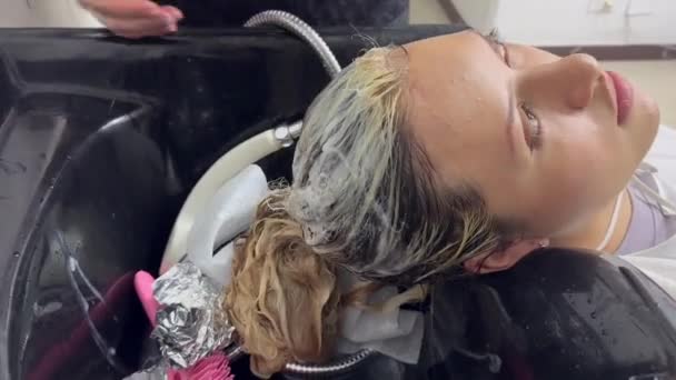 Mladá Žena Kadeřnickém Salonu Její Kadeřnice Myjí Vlasy Pro Léčbu — Stock video