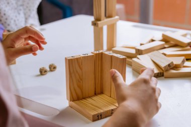 Uluslararası Çocuk Günü. Beyaz bir masada bloklarla oynayan güzel Latin çocuklar. Oyuncu, eğlenceli ve düşünceli oyunlar. Mutlu çocuklar evde..