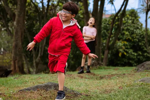 International Children Day. Very happy Latino children playing outdoors, running and smiling. Concept of family and fun. Nature.