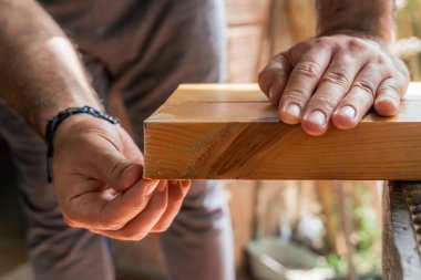 Evde el testeresiyle çalışan bir adam. Latinler odun kesip onarıyor. Marangozluk aletleri.