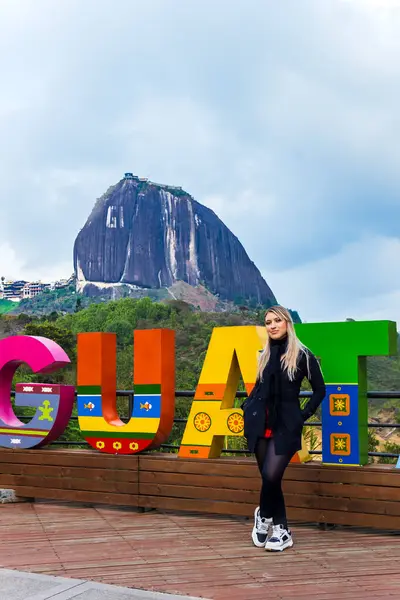 stock image Latin woman with black scarf visiting a well known village in Colombia. Guatape giant stone. Holidays and landscapes.