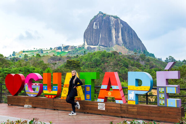 Латиноамериканка с черным шарфом посетила известную деревню в Колумбии. Гигантский камень Гватапе. Праздники и пейзажи.