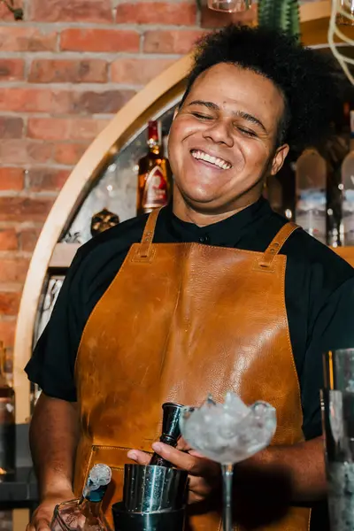 Afro-Amerikalı barmen, bir afrobeat etkinliğinde barda kokteyl hazırlıyor. Gece hayatı, parti ve barmenlik. Biçim.