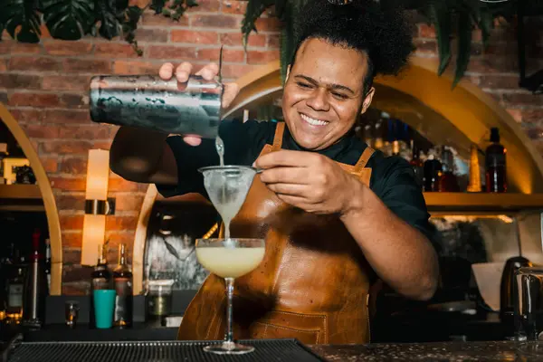 Afro-Amerikalı barmen, bir afrobeat etkinliğinde barda kokteyl hazırlıyor. Gece hayatı, parti ve barmenlik. Biçim.