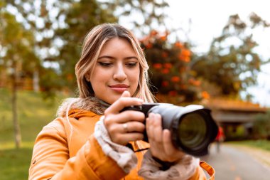 Sıcak bir günde tatilde fotoğraf çeken Latin kadın fotoğrafçı. Doğa ve güneş ışığı. Dünya Fotoğraf Günü.