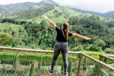 Şapkalı Latin kadın, Kolombiya 'daki Cocora Vadisi' nin manzarasına bakıyor. Aile seyahatleri ve deneyimler.
