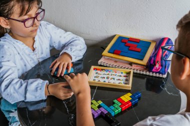 Gözlüklü Latin çocuklar, evde ders çalışıyorlar ve ödev yapıyorlar. Okula dönelim. Çocukluk. Öğrenme ve beceriler.