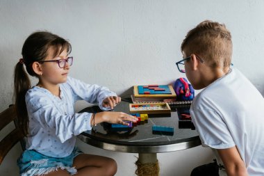 Gözlüklü Latin çocuklar, evde ders çalışıyorlar ve ödev yapıyorlar. Okula dönelim. Çocukluk. Öğrenme ve beceriler.