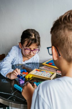 Gözlüklü Latin çocuklar, evde ders çalışıyorlar ve ödev yapıyorlar. Okula dönelim. Çocukluk. Öğrenme ve beceriler.