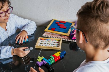 Gözlüklü Latin çocuklar, evde ders çalışıyorlar ve ödev yapıyorlar. Okula dönelim. Çocukluk. Öğrenme ve beceriler.