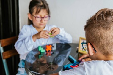 Gözlüklü Latin çocuklar, evde ders çalışıyorlar ve ödev yapıyorlar. Okula dönelim. Çocukluk. Öğrenme ve beceriler