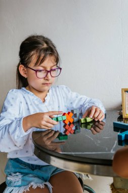 Gözlüklü Latin kız evde iş yapıyor. Defteri boyuyorum. Okula dönelim. Çocukluk ve resim.
