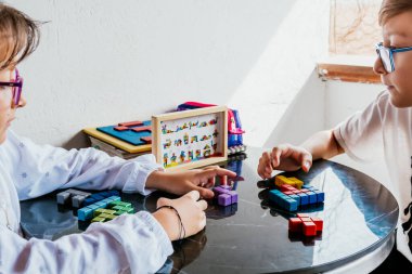 Gözlüklü Latin çocuklar, evde ders çalışıyorlar ve ödev yapıyorlar. Okula dönelim. Çocukluk. Öğrenme ve beceriler.