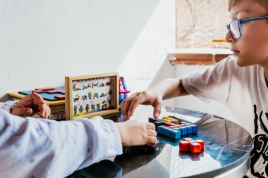 Gözlüklü Latin çocuklar, evde ders çalışıyorlar ve ödev yapıyorlar. Okula dönelim. Çocukluk. Öğrenme ve beceriler.