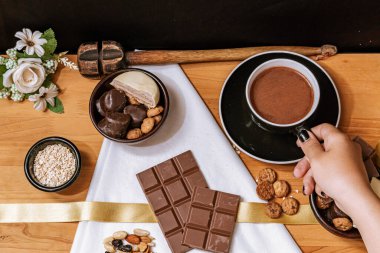 Çikolata parçacıklı kurabiye, çikolata ve beyaz çikolata, küçük kase yulaf ezmesi ve fındık. Uluslararası Çikolata Günü.