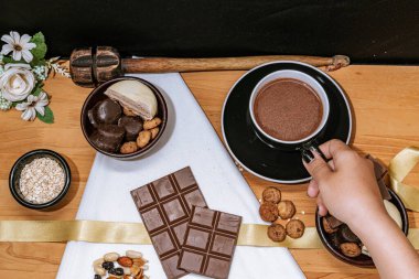 Çikolata parçacıklı kurabiye, çikolata ve beyaz çikolata, küçük kase yulaf ezmesi ve fındık. Uluslararası Çikolata Günü.