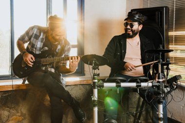 Arkadaşlar evde prova yapıyor, gitar ve davul çalıyor. Müzik grubu. Uluslararası müzik günü.