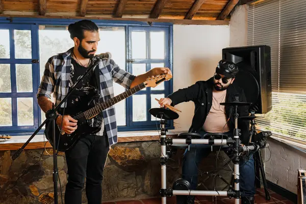 Arkadaşlar evde prova yapıyor, gitar ve davul çalıyor. Müzik grubu. Uluslararası müzik günü.