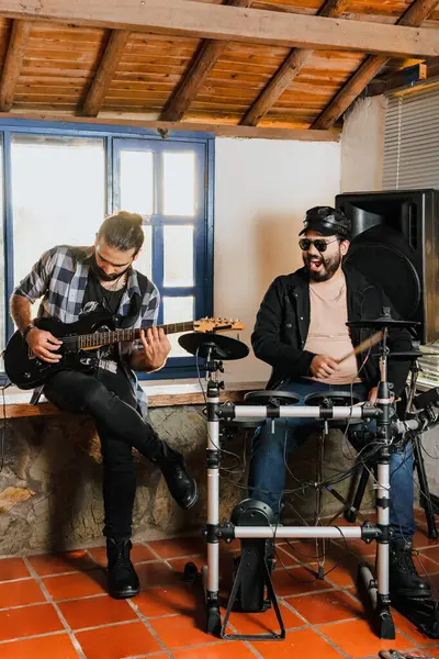 Arkadaşlar evde prova yapıyor, gitar ve davul çalıyor. Müzik grubu. Uluslararası müzik günü.