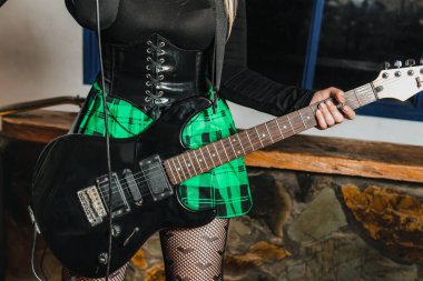 Bas gitar çalan kadın şarkıcı. Grubun provası evde. Uluslararası müzik günü.