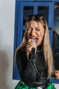 Bas gitar çalan kadın şarkıcı. Grubun provası evde. Uluslararası müzik günü.