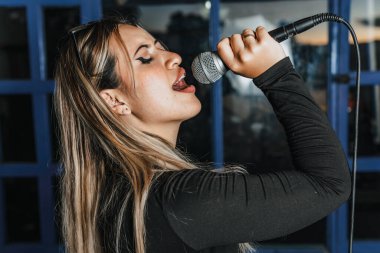 Bas gitar çalan kadın şarkıcı. Grubun provası evde. Uluslararası müzik günü.