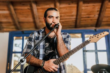 Elektro gitar çalan erkek şarkıcı. Grubun provası evde. Uluslararası müzik günü.