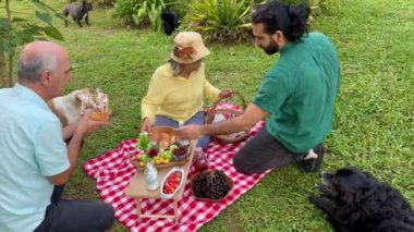Oğlu piknik gününü ailesiyle paylaşıyor. İnsanlar yudumluyor. Mutlu Latin ailesi.