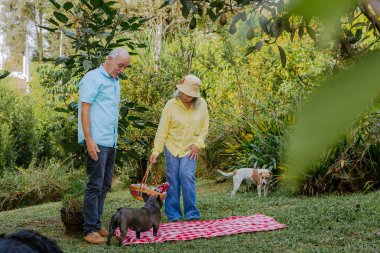 Çift, aile pikniği için eşyalarını hazırlıyor. İnsanlar gülümsüyor.