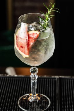 Güzel bir barda greyfurtlu ve biberiyeli cin ve tonik karışımını tazeliyorum..