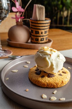 Fındıklı kurabiye, vanilyalı dondurma ve tahtadan bir masada kahverengi tabakta fındık. Lüks otel restoranı..