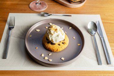 Fındıklı kurabiye, vanilyalı dondurma ve tahtadan bir masada kahverengi tabakta fındık. Lüks otel restoranı..